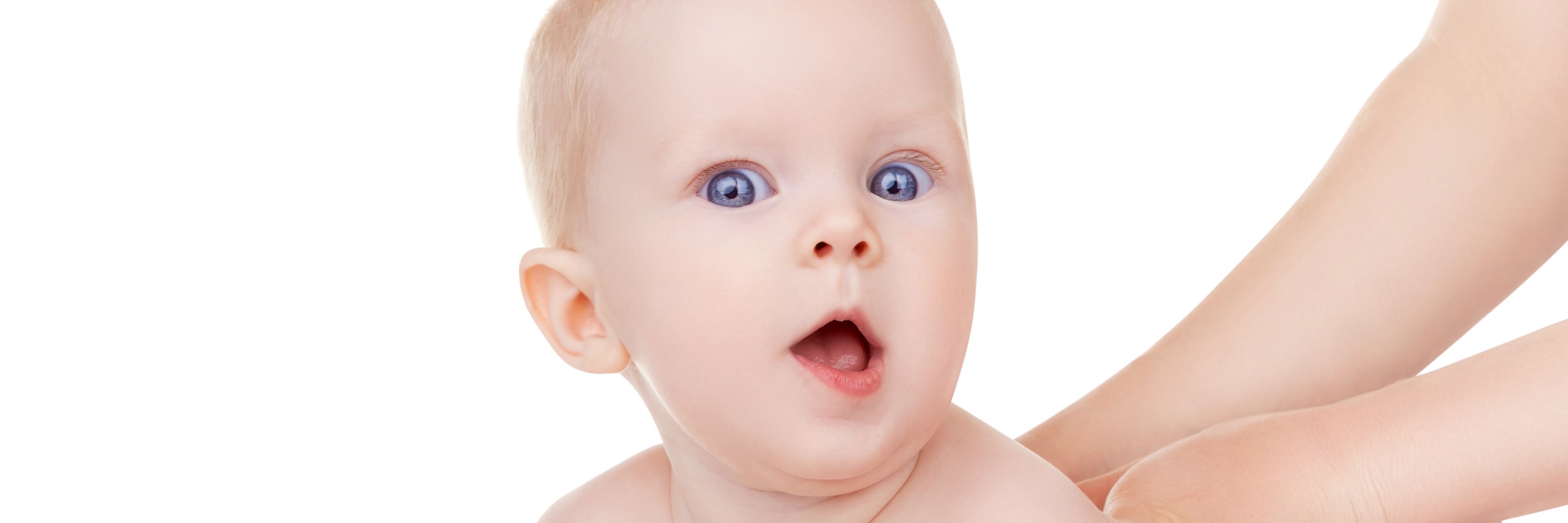 Baby der ligger på maven og løfter hovedet.