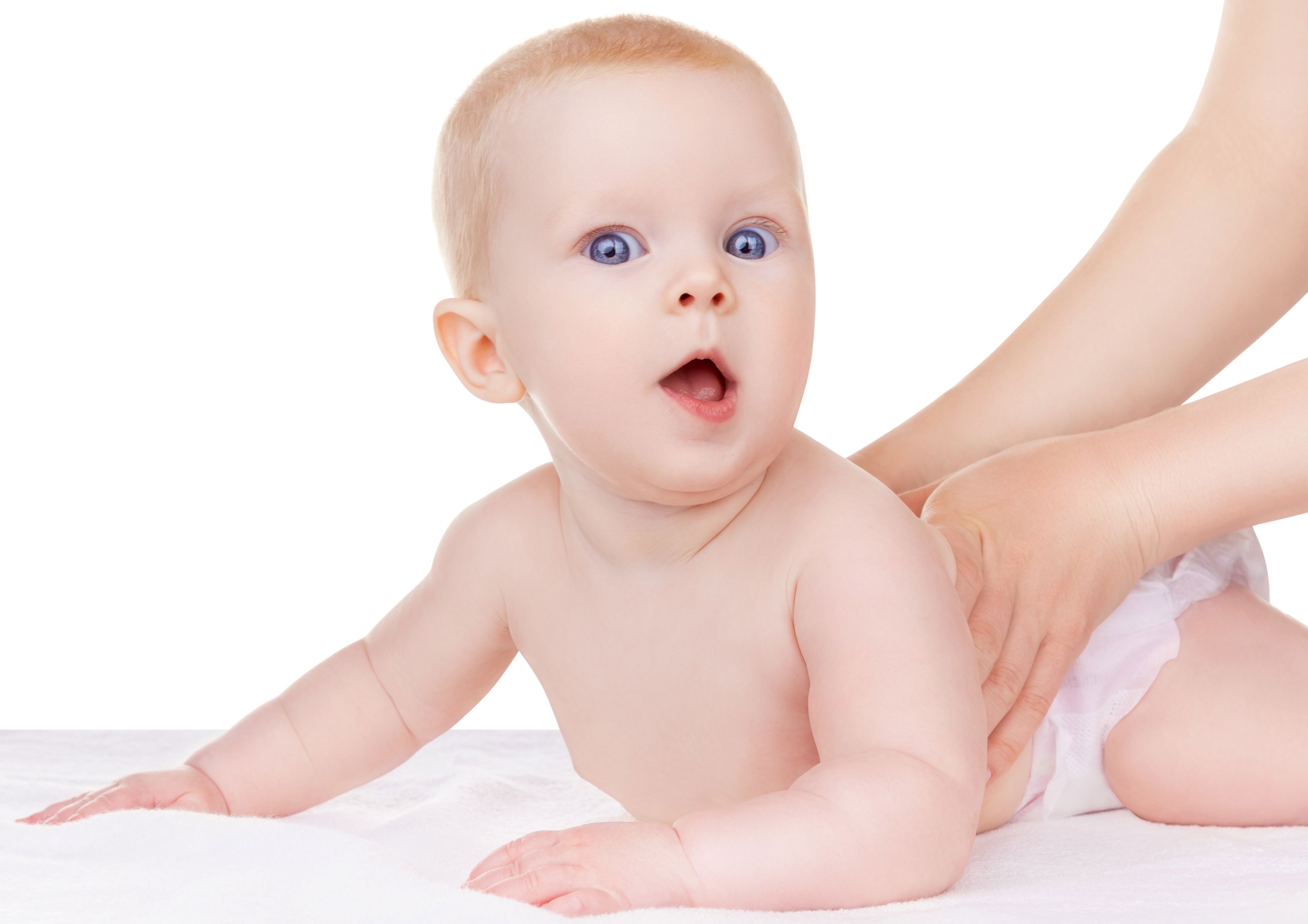 Baby der ligger på maven og løfter hovedet.
