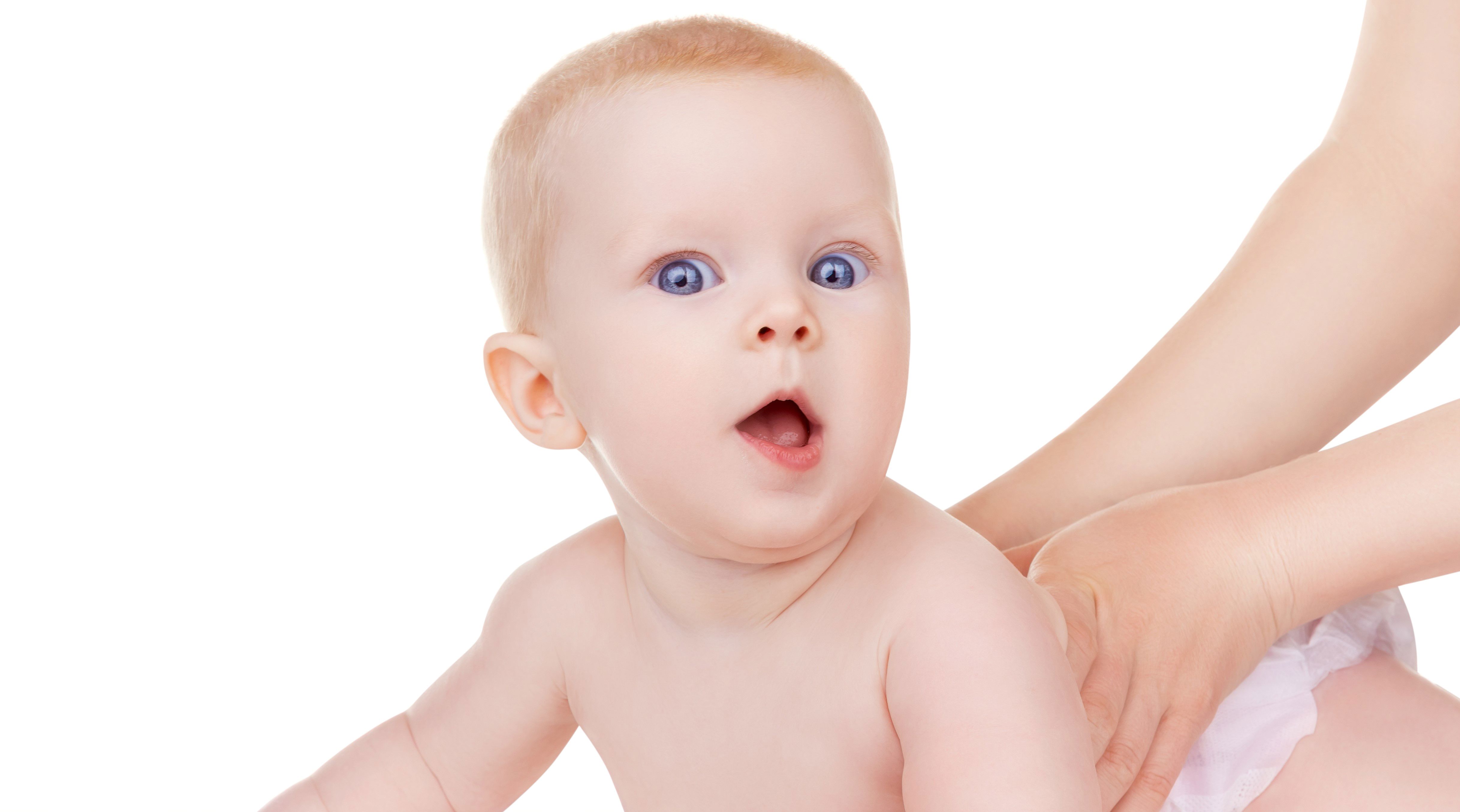 Baby der ligger på maven og løfter hovedet.