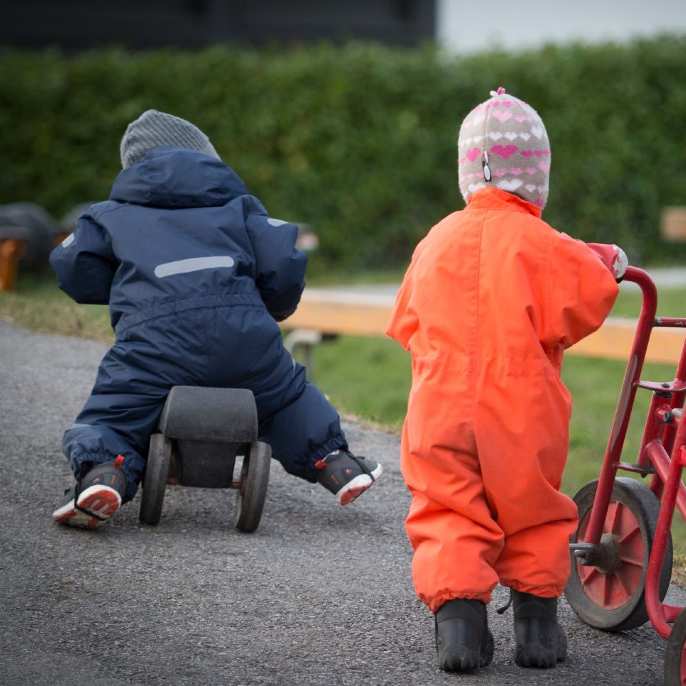 To småbørn udenfor på legeplads