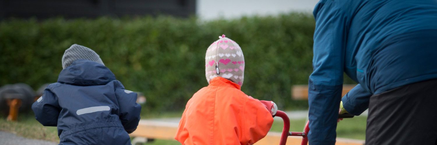 To småbørn udenfor på legeplads