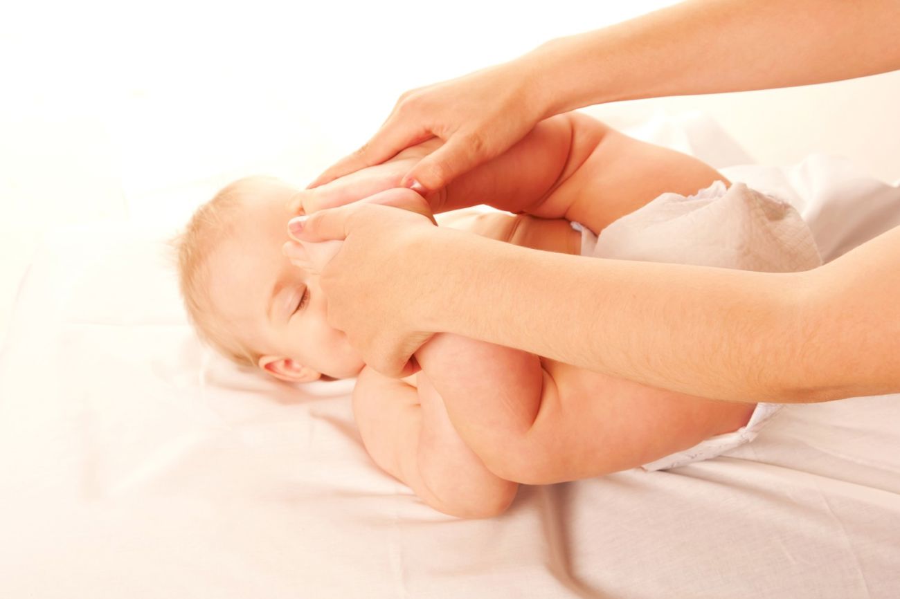 En forælder laver gymnastik med sin baby