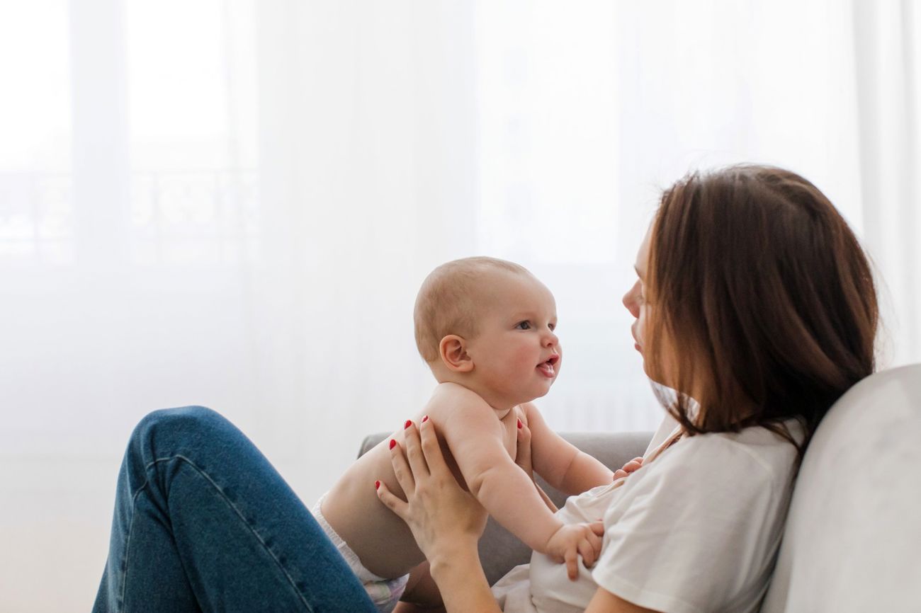 Mor og baby sidder med front mod hinanden og taler sammen